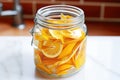 citrus peels soaking in jar of white vinegar