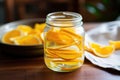 citrus peels soaking in jar of white vinegar