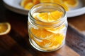 citrus peels soaking in jar of white vinegar