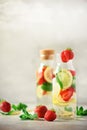 Citrus and strawberry lemonade with mint, lemon on grey background. Detox drink. Summer fruit infused water. Copy space. Royalty Free Stock Photo
