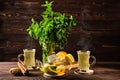 Citrus tea with ginger and mint leaves in a glass teapot, dark food photography