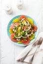 Citrus vitamin salad. Orange, grapefruit, ricotta cheese, pine nuts, red onions and rucola with olive oil in a ceramic plate on a