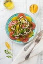 Citrus vitamin salad. Orange, grapefruit, ricotta cheese, pine nuts, red onions and rucola with olive oil in a ceramic plate on a