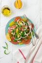 Citrus vitamin salad. Orange, grapefruit, ricotta cheese, pine nuts, red onions and rucola with olive oil in a ceramic plate on a