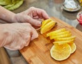 Citrus Zest: Skillful Chef Slices Fresh Lemon Circles on a Rustic Wooden Board in the Vibrant Kitchen