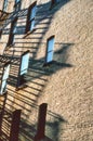 City Apartment Building and Fire Escapes and Sunset - Reflection windows Royalty Free Stock Photo