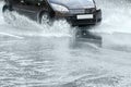 City asphalt road during heavy rain. black car in motion. Royalty Free Stock Photo