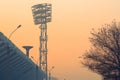 City background silhouette stadium spotlights, bowl for the olympic torch and tree covered with snow at sunset. Stadium Royalty Free Stock Photo