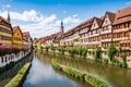 The city of Bamberg has a panorama with a river, half-timbered colorful houses on water and a boat.