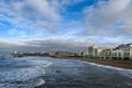 Some waves on the beach next to the city with a lighthouse in the background Royalty Free Stock Photo