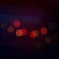 City blurry red orange yellow night bokeh lights through glass window in blue rainy evening with drop water Royalty Free Stock Photo
