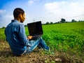 A city boy holded laptop at green field area in India January 2020 Royalty Free Stock Photo