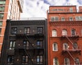 City brick apartment building exterior with fire escapes