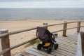 Strollers stand by the sea, surrounded by nature and fresh air
