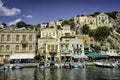 Greek island with pastel colored houses under clear blue skies