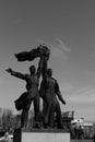 The city center, a magnificent square, a stone pedestal, a monument to workers, the sky and light clouds.