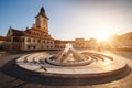 City central square (Piata Sfatului) with town council hall tower, fountain morning sunrise view, location Brasov, Transylvania, Royalty Free Stock Photo