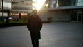 city-dweller in downtown in morning, portrait of stylish person against sun in autumn or spring