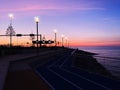 city Evening promenade at port pier city light people walking on horizon sunset pink sea and sky panorama Tallinn Estonia Royalty Free Stock Photo