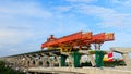 City expressway under construction with huge modern mechanical equipment. Big heavy machine crane on giant pillars during express