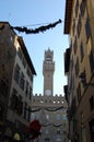 City Hall in Florence, the clock tower. Ancient buildings with shutters on the windows.