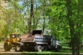 The city improvement team removes the fallen leaves in the park with an excavator and a truck. Regular seasonal work on improving