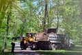 The city improvement team removes the fallen leaves in the park with an excavator and a truck. Regular seasonal work on improving