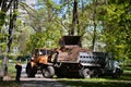 The city improvement team removes the fallen leaves in the park with an excavator and a truck. Regular seasonal work on improving