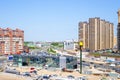 City intersection with moving cars and high residential buildings, mirror building in the center. Krasnodar, Russia