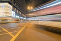 City intersection under night lights as cars and buses pass in z Royalty Free Stock Photo