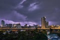 City landscape lightning storm behind clouds at night and highway light trails