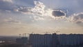 City landscape with new houses under construction on a background of cloudy sky with sunnlight. Aerial view of the drone Royalty Free Stock Photo