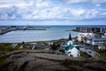 A city landscape from a rocky hill in Hafnafjordur, Green roof church, fishing harbour and Atlantic ocean, Iceland.