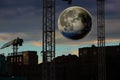 City landscape under big moon at night. Fantastic urban cityscape