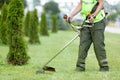 City landscaper worker cutting grass with string lawn trimmer Royalty Free Stock Photo