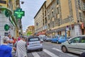 City life in an evening in Nice, France. The street with a pharmacy and other shops is filled with cars and people