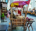 City life style girl sells roasted almonds in the Old Town of Tallinn for a tourist trip to the Baltic tourism 2019,06,20