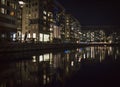 City lights reflected in water. Silhouette under a streetlight.