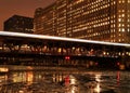 City night lights are illuminated from Chicago bridge and moving el train speeding across it. Royalty Free Stock Photo