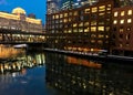 City night lights reflect gorgeously on freezing Chicago River during winter evening rush hour.