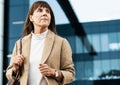 City, office and senior business woman waiting for a lift, taxi or cab outside the corporate building. Serious Royalty Free Stock Photo