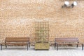 City park background. Wooden benches, wooden pergola with flowerbed near red brick wall