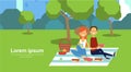 City park couple sitting picnic eating on green lawn man woman trees cityscape background copy space horizontal flat
