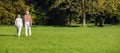 City park, Munich, Germany. View of a mature couple walking on the grass