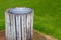 wooden fence covers a aluminum trash can in a urban park Royalty Free Stock Photo