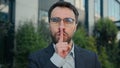 City portrait Caucasian business man businessman outdoors showing silence hush lips gesture keep secret secrecy Royalty Free Stock Photo