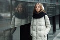 City portrait of young beautiful blonde stylish girl posing in spring fall outdoors in white coat black knitted scarf. Vintage fil Royalty Free Stock Photo