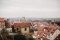 City of Prague with red roofs and Church in fog. City view of Praha old city. Rustic grey colors toning Royalty Free Stock Photo