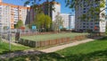 In the city quarter, among residential buildings, next to grass lawns and trees, there are sports grounds for basketball and footb