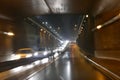 Road traffic in rainy night tunnel with cars and lights blur effect Royalty Free Stock Photo